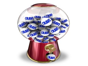 Crave word on gum balls in a candy machine or snack dispenser to illustrate a craving, appetite or hunger for sweets or junk food